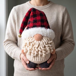 May include: A plush gnome figurine featuring a tall, red and black buffalo plaid hat with a small gold bell at the tip. The gnome has a white faux fur trim, a round peach-coloured nose, a textured cream-coloured beard, and dark grey feet.