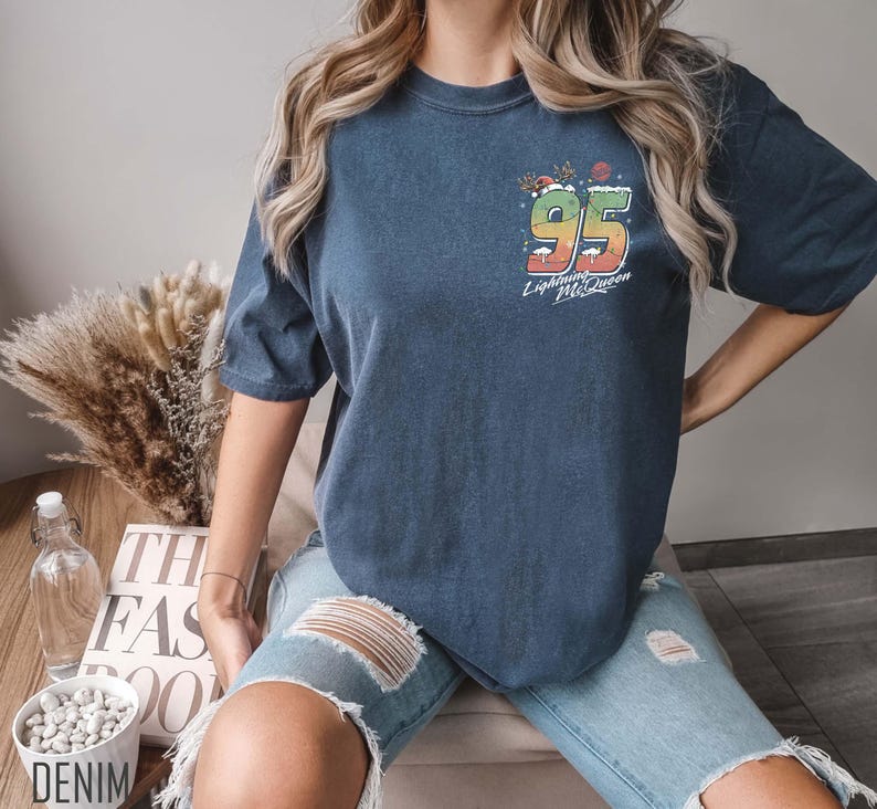 Puede incluir: Una camiseta azul oscuro con un gr&aacute;fico colorido del n&uacute;mero 95 y el texto "Lightning McQueen".