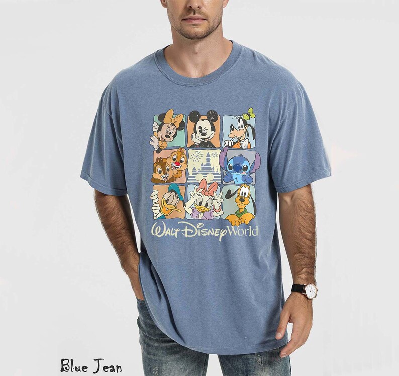 Op de afbeelding: Blauw T-shirt met een kleurrijke afbeelding van Disney-personages in een rasterpatroon. Het ontwerp bevat Mickey Mouse, Minnie Mouse, Donald Duck en Stitch. De tekst "Walt Disney World" staat eronder.