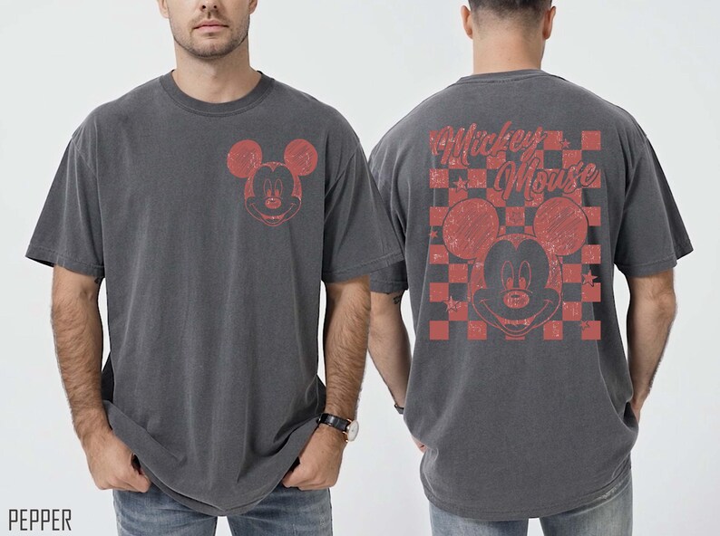 May include: Charcoal gray t-shirt featuring a distressed red Mickey Mouse graphic on the front and back. The back design includes a checkered pattern and the words "Mickey Mouse". The shirt has a vintage, worn look.