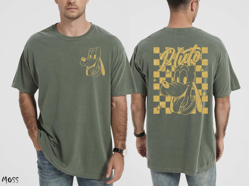 May include: Moss green t-shirt featuring a Pluto graphic. The front has a small Pluto design, while the back displays a larger Pluto image with the word "Pluto" in a stylized font, set against a yellow and black checkered background.