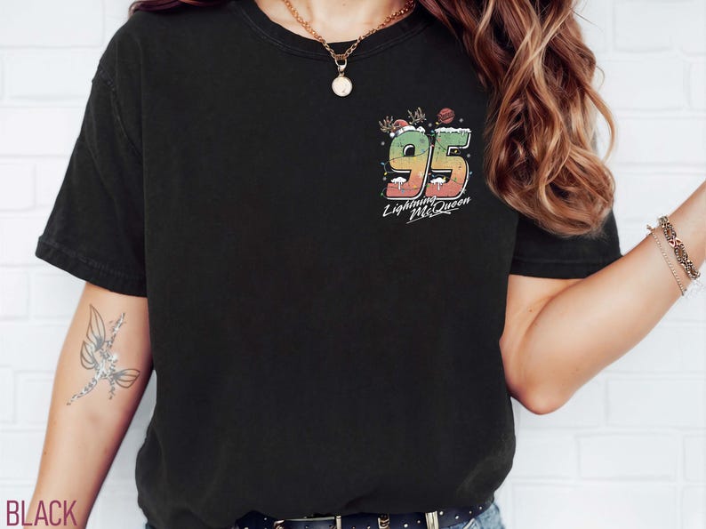 Puede incluir: Camiseta negra con un gr&aacute;fico colorido del n&uacute;mero 95 y el texto "Lightning McQueen".