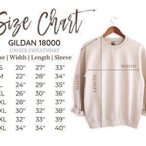 May include: A beige Gildan 18000 unisex sweatshirt hangs on a wooden hanger. The image includes a size chart with measurements in inches for width, length, and sleeve length, ranging from size S to 5XL. The chart is labeled "Size Chart".