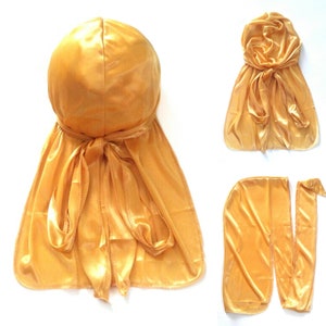May include: A gold satin durag with a tied knot at the back. The durag is shown in three different positions: tied on a head, laid flat, and with the tie strings separated.