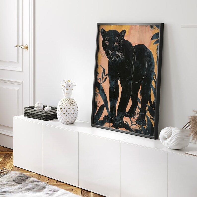 May include: A black panther silhouette print with a peach background and gold leaf accents. The print features a black panther walking through a jungle scene.