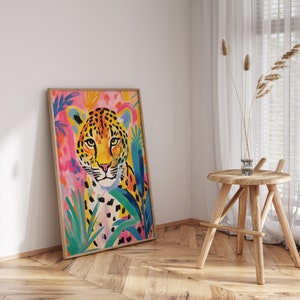 May include: A framed painting of a leopard with a colorful background of pink, blue, and green. The leopard is looking directly at the viewer with a serious expression.