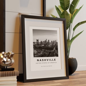 以下が含まれることがあります： ナッシュビルのスカイラインの白黒写真。写真の下には「NASHVILLE, UNITED STATES OF AMERICA, 36.1718&deg; N 86.7850&deg; W」というテキストが印刷されています。