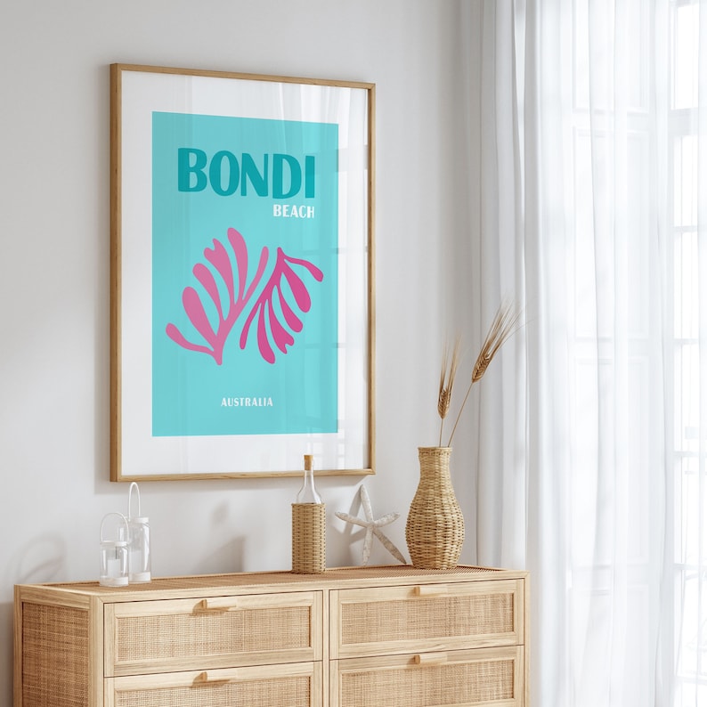 May include: A framed poster with a blue background and pink stylized leaves. The poster says "Bondi Beach Australia".