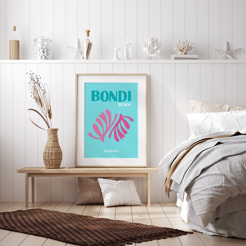May include: A framed poster with a teal background and pink stylized leaves. The poster says "Bondi Beach Australia" in white text.