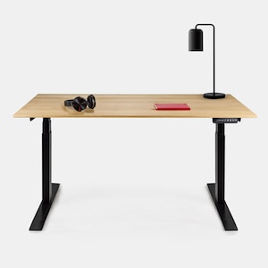 Peut inclure: Un bureau en bois avec un cadre noir réglable en hauteur. Le bureau est équipé d'une lampe noire avec un abat-jour cylindrique, d'un casque audio et d'un carnet rouge.