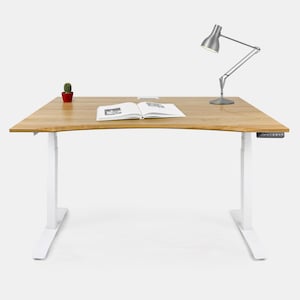 Pode incluir: Uma mesa de pé branca com tampo de madeira. A mesa tem um pequeno cacto em vaso e um livro no topo. Uma lâmpada de mesa prateada está do lado direito da mesa.