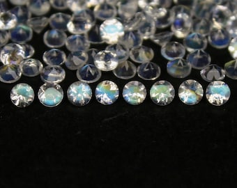 May include: A collection of iridescent clear gemstones, with a row of 10 gemstones in the foreground.