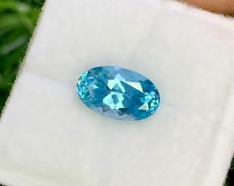 May include: A light blue oval-shaped gemstone in a white velvet box.