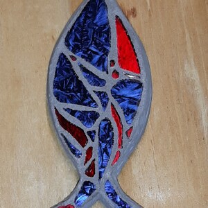 May include: A blue and red stained glass fish ornament with a silver loop for hanging.
