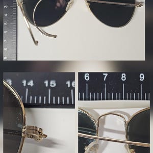 Pu&ograve; includere: Occhiali da sole stile aviatore con montatura in metallo dorato e lenti scure. Gli occhiali misurano circa 15 cm di larghezza. L'immagine include dettagli in primo piano delle cerniere e dei naselli. Un righello &egrave; sullo sfondo.