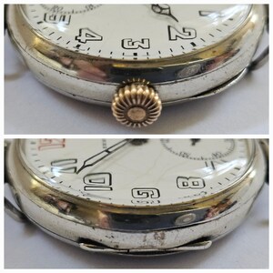 Op de afbeelding: Een zilveren zakhorloge met Romeinse cijfers op de wijzerplaat. Het horloge heeft een gouden kroon en een witte wijzerplaat met zwarte wijzers.