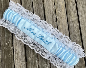 Embroidered personalised garter in pale blue with a darker blue embroidery thread colour.