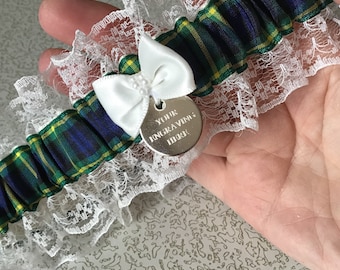 May include: A white lace garter with a blue, green, and yellow plaid ribbon and a silver charm that says "Your Engraving Here".