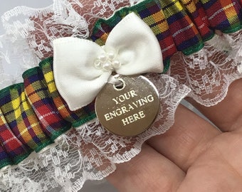 May include: White lace garter with a red, yellow, green, and blue plaid ribbon and a white satin bow. A silver charm with the text "YOUR ENGRAVING HERE" hangs from the bow.