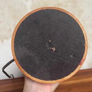 May include: The bottom of a wooden lamp base with a black fabric covering. The base has a dark brown wood finish.