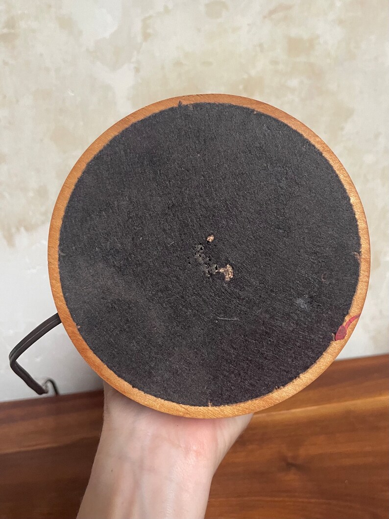 May include: The bottom of a wooden lamp base with a black fabric covering. The base has a dark brown wood finish.