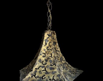 May include: A hanging pendant lamp featuring a flared, four-sided metal shade with a textured, hammered gold and dark patina finish. The shade has irregular, cut-out openings throughout its surface and is suspended by a matching metal chain.