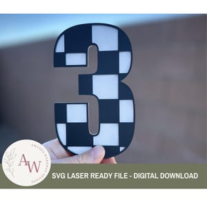 May include: A black and white checkered number three. The number is held in front of a blurred background. The text "SVG LASER READY FILE - DIGITAL DOWNLOAD" is at the bottom of the image.