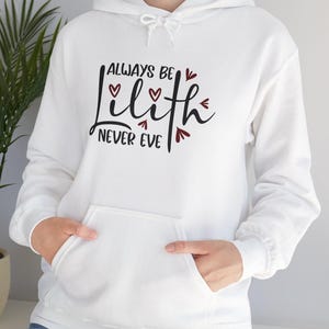 May include: White hooded sweatshirt with the text "Always be Lilith Never Eve" in black lettering with red hearts.