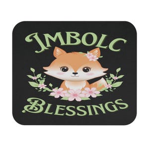 Puede incluir: Posavasos cuadrado negro con una ilustración de un zorro de dibujos animados. El zorro es naranja y blanco, con flores rosas y hojas verdes. El texto "IMBOLC BLESSINGS" está en verde, con una escritura estilizada.