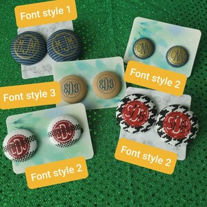 Puede incluir: Cuatro pares de botones cubiertos de tela con diferentes estilos de fuente y patrones. Los botones son de varios colores, incluidos azul, tostado, rojo y blanco. El texto en los botones incluye las letras "MJM", "CNW", "EDS" y "SDB".