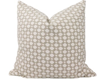 May include: A beige throw pillow with a white geometric pattern. The pillow is made of a soft, textured fabric.