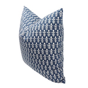 May include: A blue and white patterned throw pillow with a leaf design. The pillow is made of a soft, comfortable fabric and is perfect for adding a touch of style to any room.
