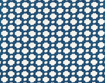 May include: A blue fabric with a white geometric pattern. The pattern is made up of small, repeating shapes that resemble stars.