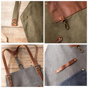 May include: Close-up of a canvas apron with leather accents. The apron features adjustable straps, metal hardware, and a pocket. The apron is in shades of gray, olive green, and brown, with a focus on the details of the construction.