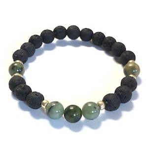 Op de afbeelding: Een armband van zwarte lavasteen en groene jade kralen met gouden tussenstukken.