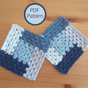 Può includere: Due quadrati all'uncinetto in tonalità di blu e grigio. I quadrati sono realizzati con un motivo a punto granny. Il testo "PDF Pattern" è visibile in un cerchio sopra i quadrati.