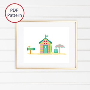 Pode incluir: Um padrão de ponto cruz que apresenta uma cabana de praia com um exterior listrado rosa e amarelo, uma porta verde e uma prancha de surf. Há uma placa verde que diz "Praia" com um pássaro no topo, uma cadeira verde e um guarda-sol listrado.