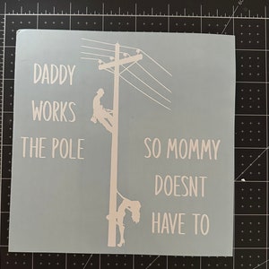 May include: White vinyl decal with the text "Daddy works the pole so mommy doesn't have to". The decal features a silhouette of a person climbing a utility pole.