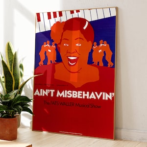 Puede incluir: Un póster enmarcado para "Ain't Misbehavin'" The Fats Waller Musical Show. El póster presenta una ilustración estilizada de una mujer con rostro naranja y vestido rojo, con el título del espectáculo en texto blanco.