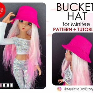 Op de afbeelding: Een roze bucket hat voor een pop. De hoed is gemaakt van stof en heeft een eenvoudig ontwerp. De hoed wordt getoond op een pop met roze en wit haar. De afbeelding bevat ook de tekst "BUCKET HAT for Minifee PATTERN + TUTORIAL" en de social media handle "@MyLittleDollStory".
