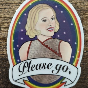 Puede incluir: Una pegatina con una mujer de pelo rubio que lleva un vestido rojo y gris. La mujer está rodeada de un arcoíris y estrellas. La pegatina tiene el texto "Please go." impreso en una pancarta blanca.