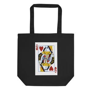 Puede incluir: Bolso tote negro con un diseño de carta de juego de la Reina de Corazones. La carta presenta una ilustración detallada en rojo, amarillo, azul y blanco. Las esquinas de la carta muestran la letra "Q" y símbolos de corazón.