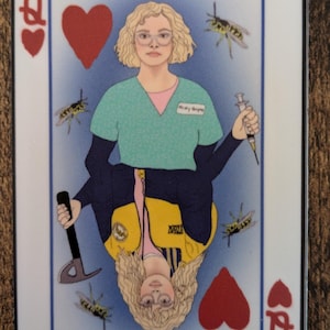 May include: A playing card featuring a queen of hearts. The queen is depicted as a woman with blonde hair wearing a green shirt, a yellow vest, and a blue jacket. She is holding a syringe in one hand and an axe in the other. There are several yellow and black wasps flying around her.