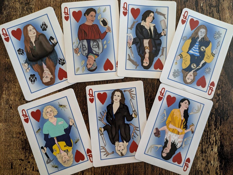 May include: A set of playing cards featuring illustrations of women with different accessories and poses. Each card is a Queen of Hearts with a red heart in the corner.