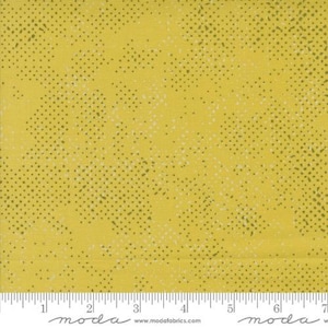 May include: Yellow fabric with a green and white speckled pattern. The fabric has a subtle texture and a slightly distressed look.