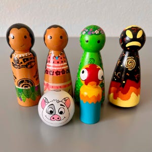 May include: A collection of six hand-painted wooden peg dolls. The dolls feature various designs, including a pig, a parrot, and characters with floral and tribal patterns. The color palette includes orange, green, black, and white.