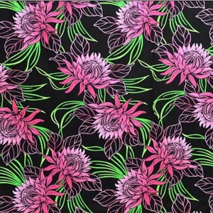 Op de afbeelding: Een zwarte stof met een roze en groene bloemenprint. De bloemen zijn gestileerd en hebben een gedetailleerd ontwerp. De stof is perfect voor knutselprojecten, quilten of het maken van kleding.