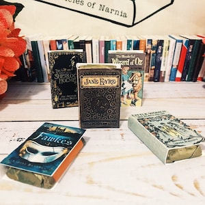 May include: Four miniature book-shaped soaps with vintage-style covers. The soaps feature titles like "The Complete Sherlock Holmes", "Jane Eyre", "The Wonderful Wizard of Oz", and "Little Women".