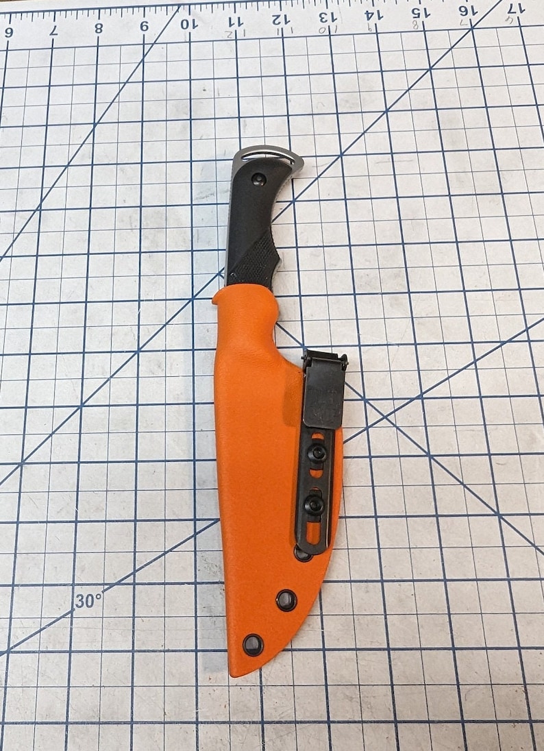 May include: An orange knife sheath with a black belt clip and a black knife handle.