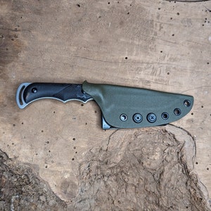 May include: A black and green knife with a textured handle and a sheath with multiple belt loops.